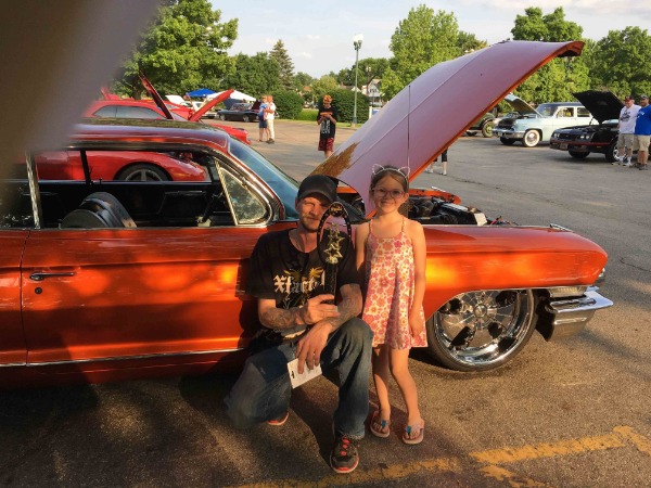 father and daughter in front of classic car