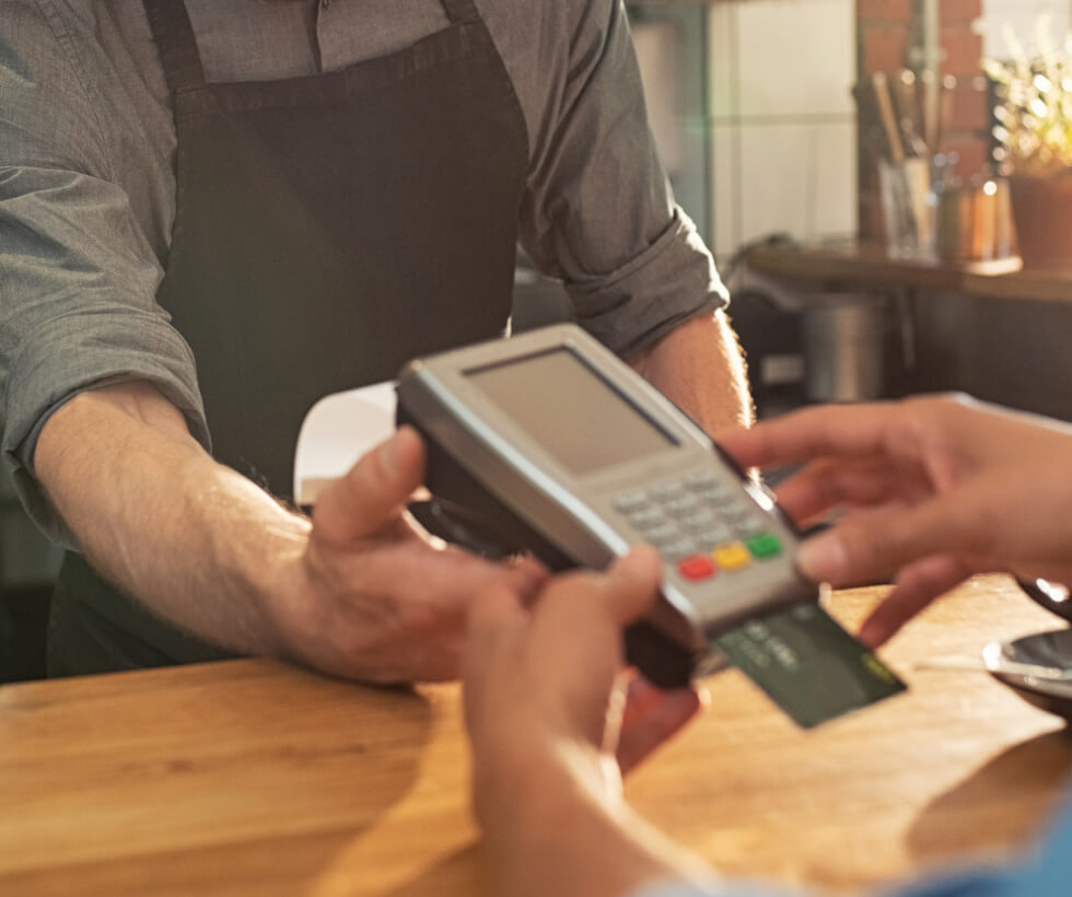 Close up of a person's hands using a credit card reader