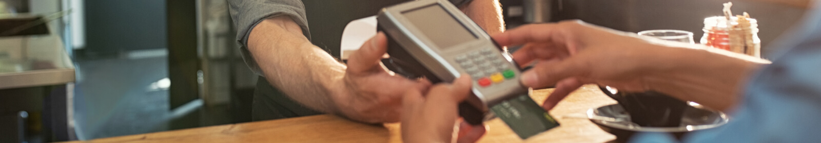 Close up of hands using a payment processor machine